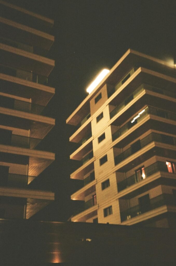 A striking view of modern apartment buildings at night showcasing urban architecture.