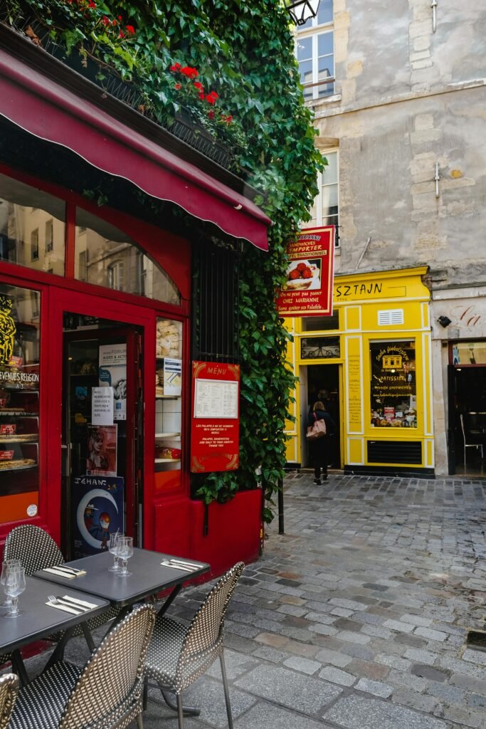 Explore a picturesque Parisian café scene with vibrant colors and ivy-covered walls on a bustling street.