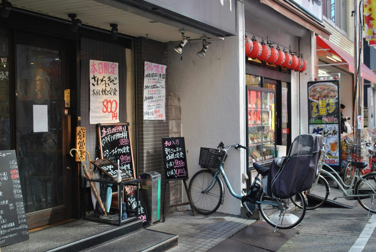 Charming urban street view with bicycles and Japanese signs in daylight.