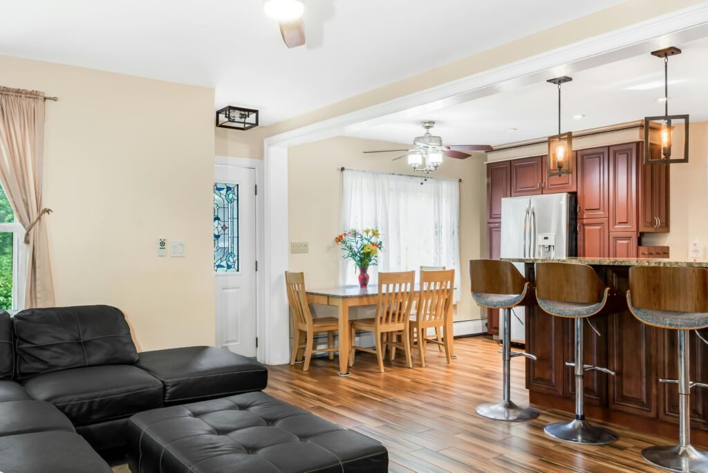 Bright and spacious kitchen and living room interior featuring wooden floors and modern furniture.