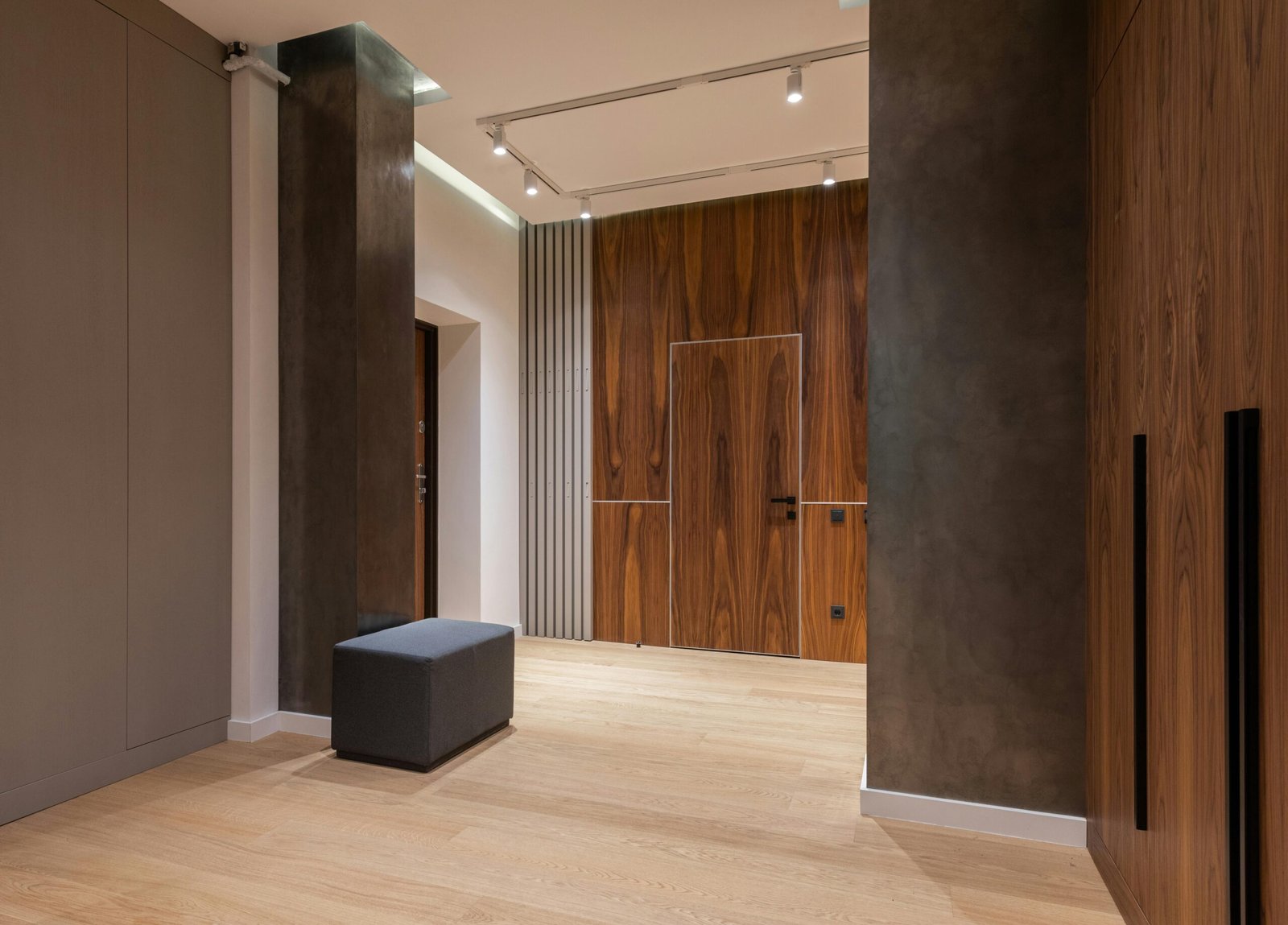 Interior of modern bright empty corridor with pouf near walls and doors under lamps on ceiling