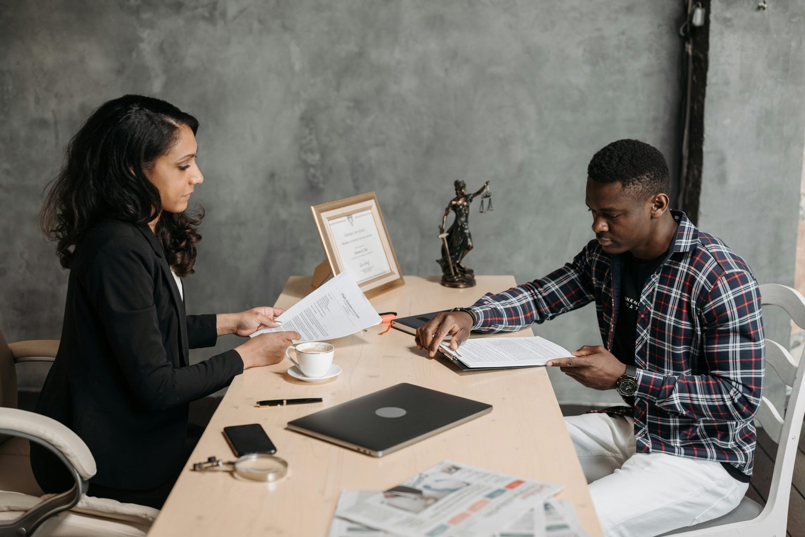 Business professionals discussing documents in a modern office setting.