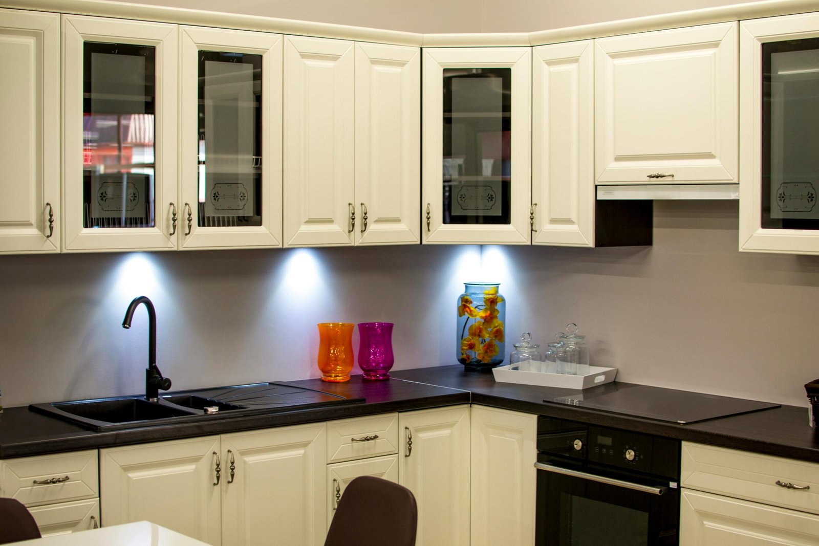 A stylish modern kitchen with white cabinets and colorful decor pieces.